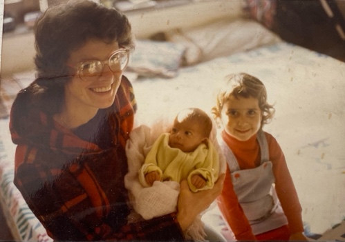 Jo McGowan Chopra holding baby Moy Moy with her older daughter beside her, 1980s family photo