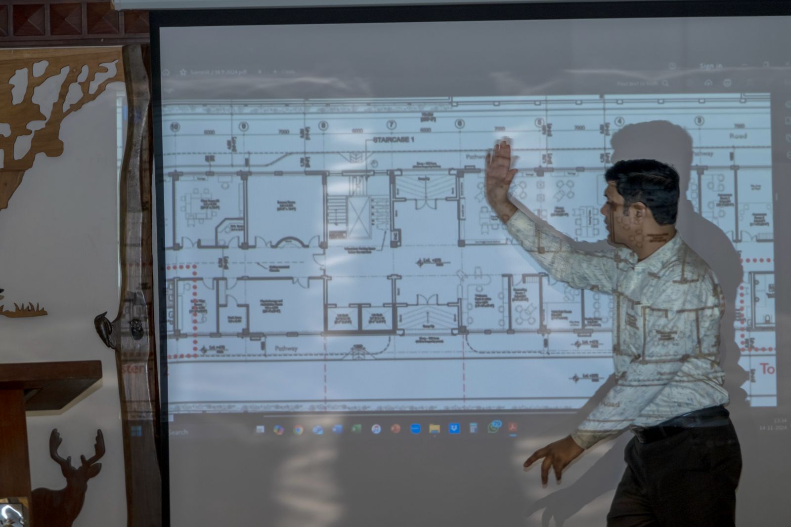 Subhash Chandra Vashishth gestures at a projected floor plan of the new Latika building during an accessibility review