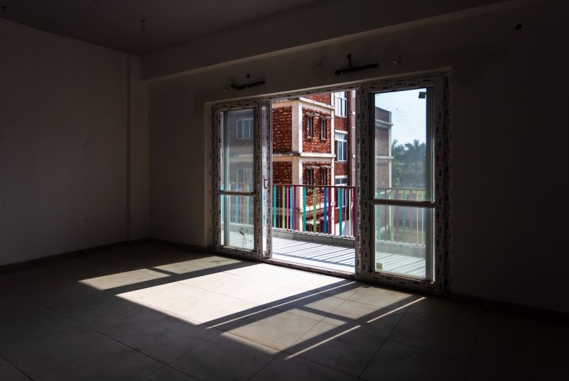 Empty classroom in the new Latika building with sunlight pouring through a glass door onto a colourful balcony