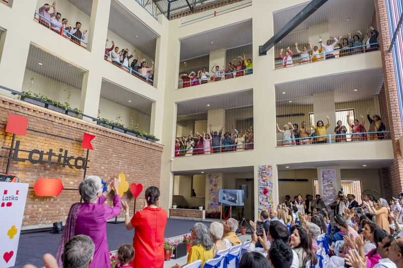 Latika staff cheer from upper balconies as the crowd below celebrates the handover of the new building