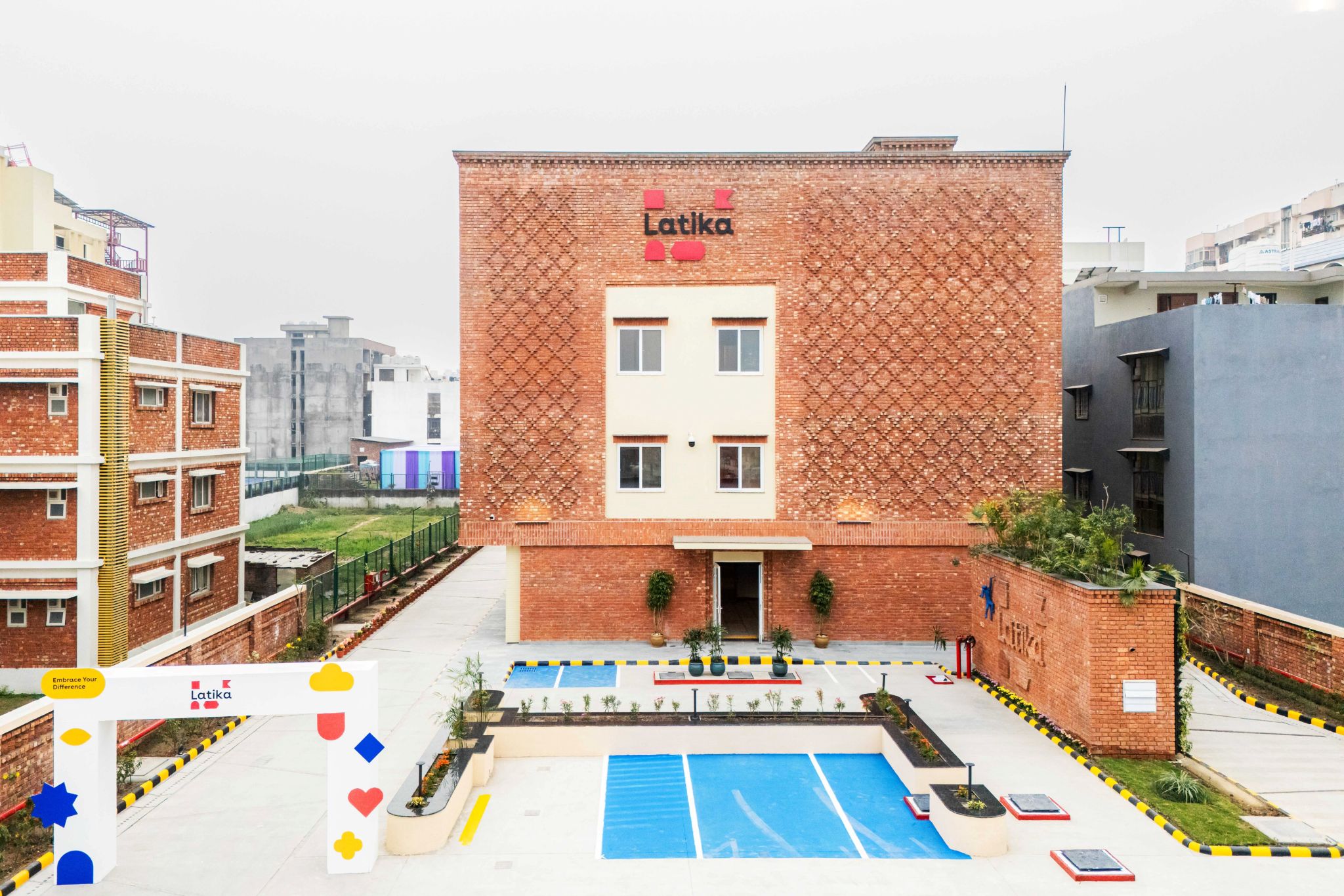 Exterior of the finished Latika Roy Foundation building with its decorative brick facade and front water feature