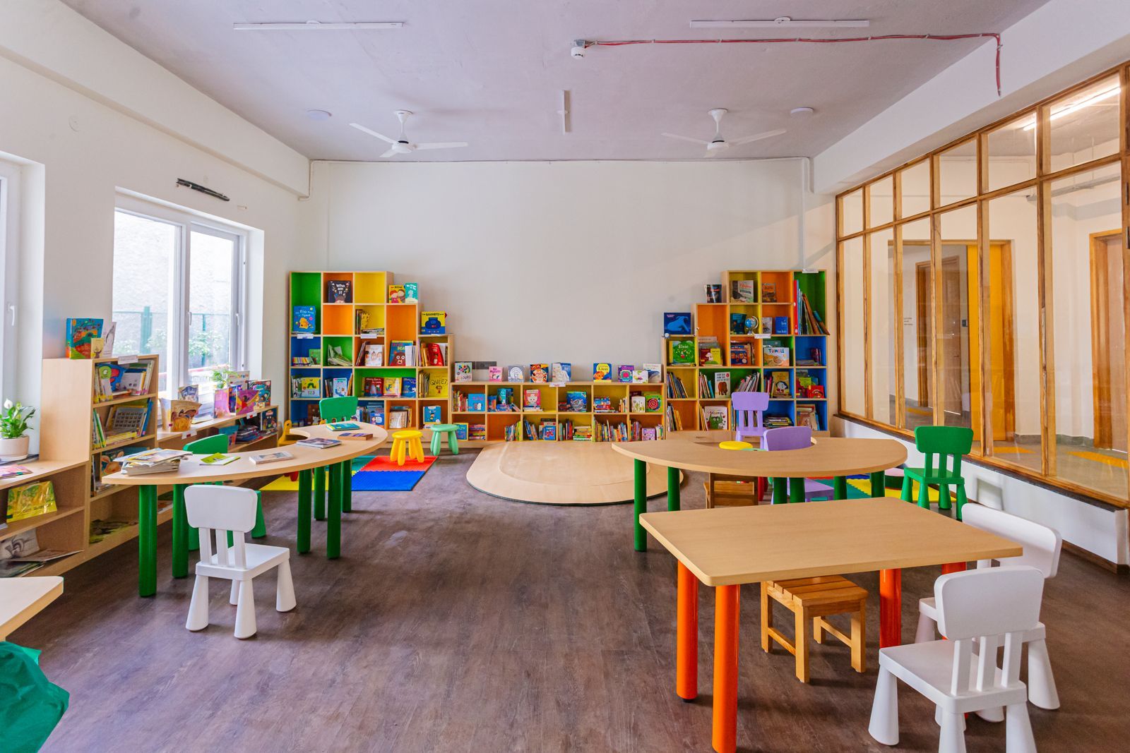 Empty Latika library interior with colourful book shelves, child-sized tables and chairs ready for use