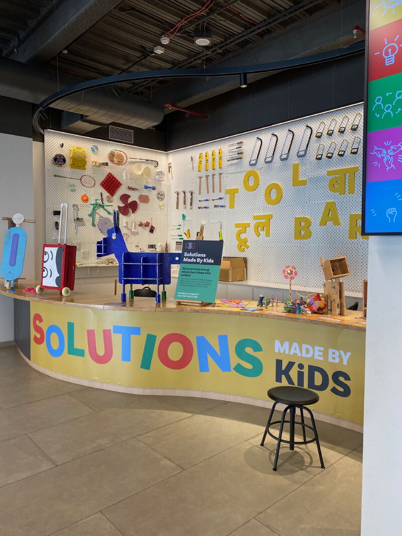 Museum of Solutions, Mumbai — colourful Tool Bar wall display behind a “Solutions Made By Kids” counter