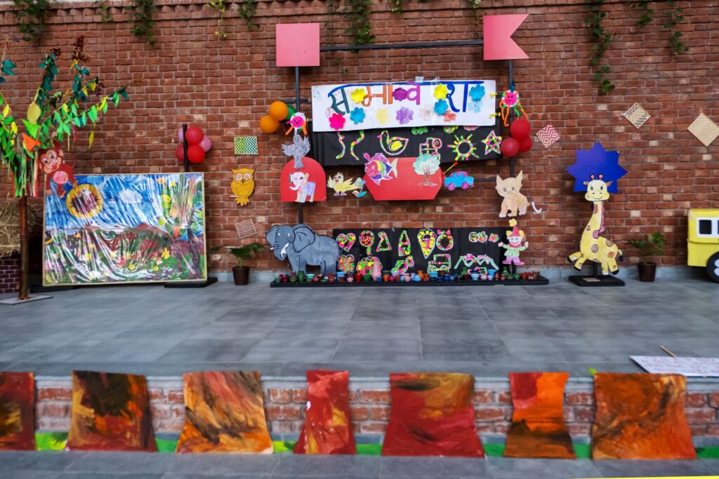 The Samavesh 2026 stage decorated with children's artwork, animal cut-outs and hand-painted pottery beneath the Samavesh banner