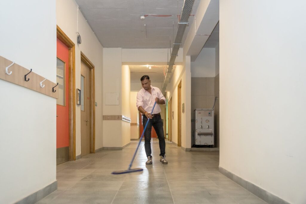 A staff member mopping a clean, bright corridor in the Latika building